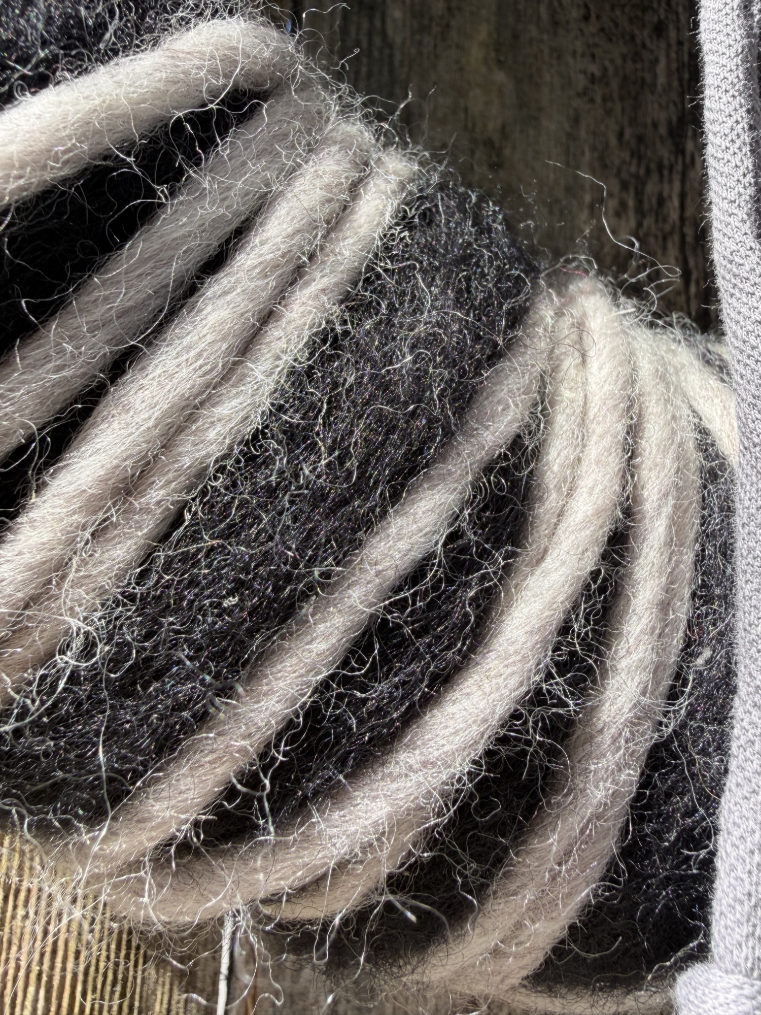 Nahaufnahme schwarz-weißer Wollkranz mit zweifarbig gewickelter Wolle – Detailansicht Naturmaterial NaturTraum Lechtal