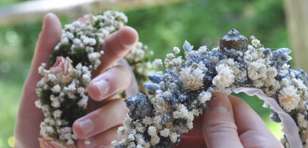 Workshop Blumenkranz – Hände binden Trockenblumenkranz mit weißem Schleierkraut und Lavendel
